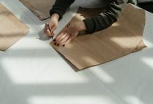 person in black and gray long sleeve shirt holding brown wooden board