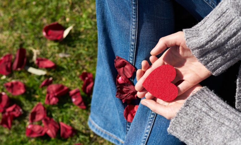 person holding heart shaped cut out